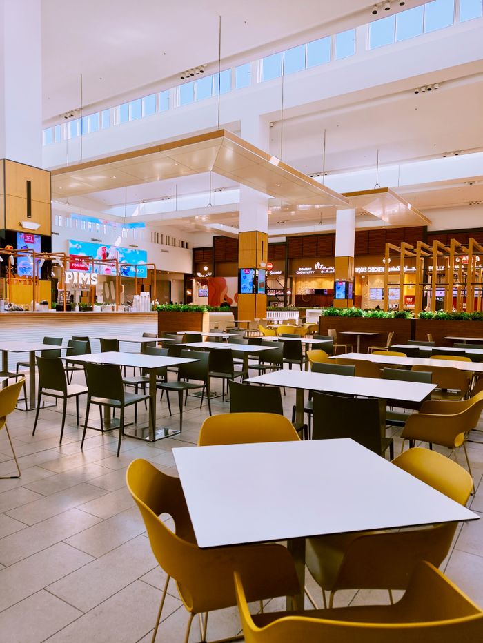 Spacious modern food court with empty tables and chairs, ideal for dining concepts.